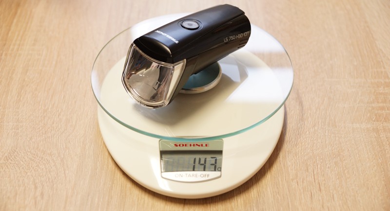 Fahrradlampe auf Waage mit Gewichtsangabe von 143 g Fahrradlampe Trelock LS 750 auf einer Waage mit Gewichtsangabe